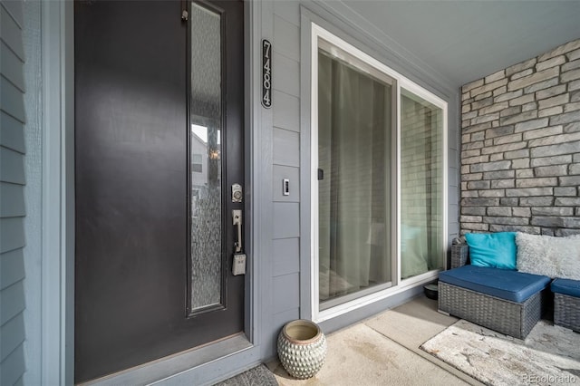 property entrance with a porch and brick siding