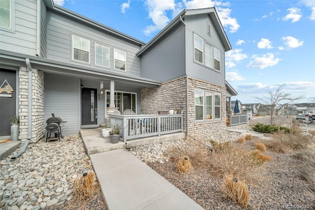 view of front facade with stone siding and covered porch