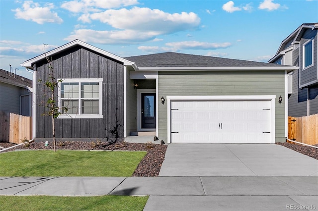 view of front of property with driveway, a garage, and a shingled roof