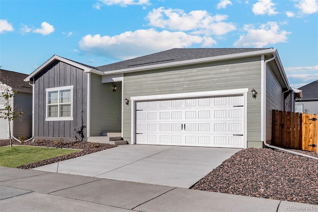 ranch-style house with a garage, concrete driveway, fence, and board and batten siding