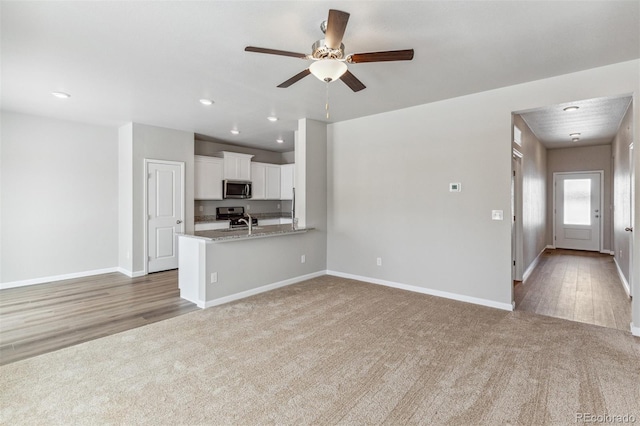 unfurnished living room featuring ceiling fan, carpet flooring, baseboards, and recessed lighting