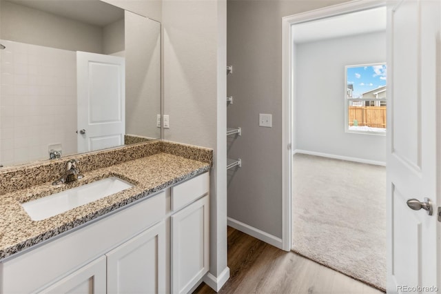 bathroom with vanity, baseboards, and wood finished floors