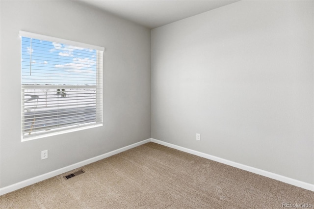 carpeted spare room featuring baseboards