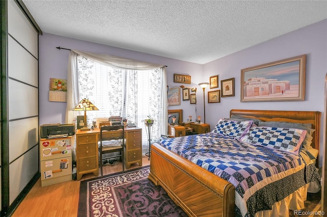 bedroom featuring a textured ceiling and wood finished floors