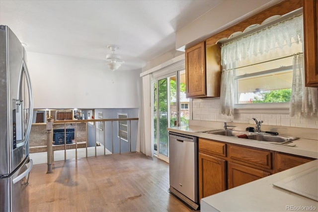 3625 E 128th Pl, Thornton, CO 80241 - kitchen featuring stainless steel appliances, brown cabinetry, light countertops, and a sink