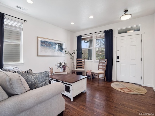 living room with recessed lighting, visible vents, and dark wood finished floors