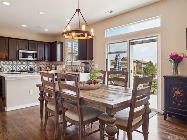 dining space featuring dark wood-style flooring, a chandelier, recessed lighting, and visible vents
