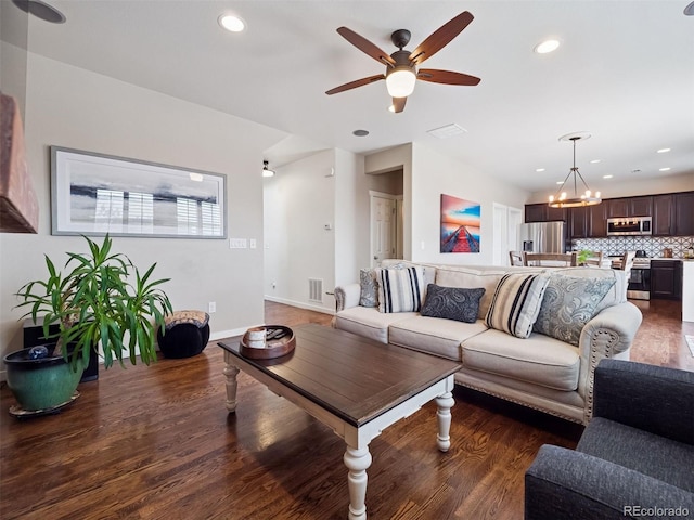 living area featuring visible vents, wood finished floors, baseboards, ceiling fan with notable chandelier, and recessed lighting
