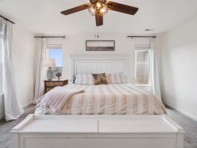 carpeted bedroom featuring baseboards, ceiling fan, and visible vents