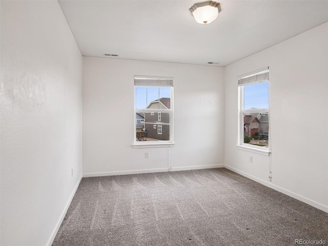 empty room featuring baseboards, carpet, and visible vents