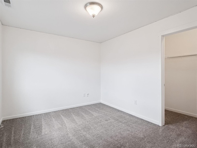 unfurnished bedroom with visible vents, a closet, baseboards, a spacious closet, and carpet