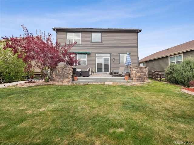 back of property featuring a lawn, fence, and a patio area