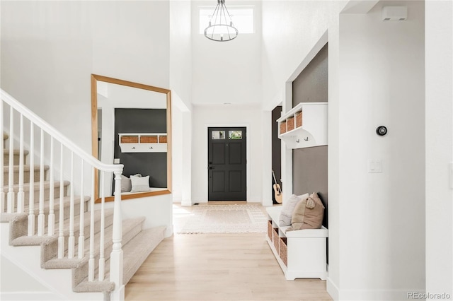 foyer with stairway, wood finished floors, and a towering ceiling