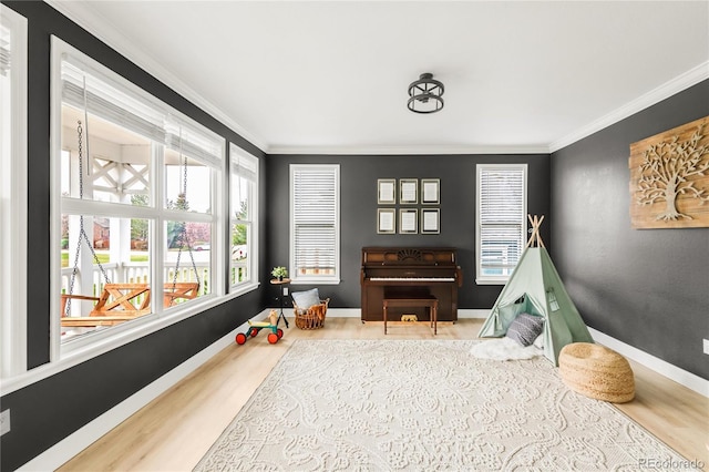 game room with crown molding, baseboards, and wood finished floors