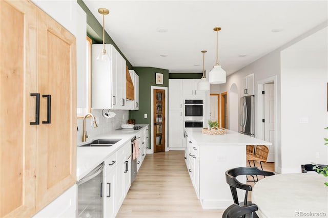kitchen with wine cooler, a breakfast bar, light wood-type flooring, a sink, and backsplash