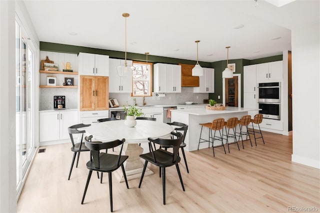 dining room featuring light wood finished floors and visible vents