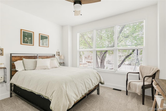 bedroom with baseboards, a ceiling fan, visible vents, and light carpet