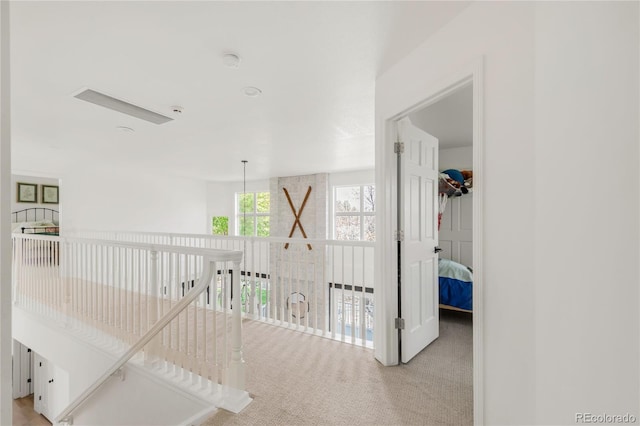 corridor featuring carpet flooring and an upstairs landing