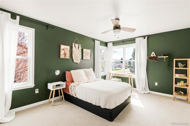 carpeted bedroom featuring baseboards and a ceiling fan