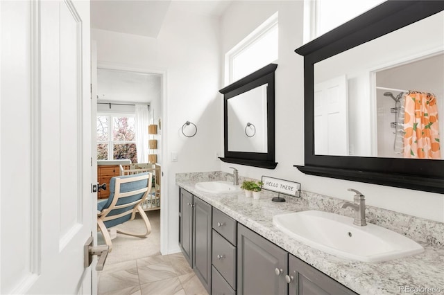 full bath with a shower with shower curtain, double vanity, and a sink