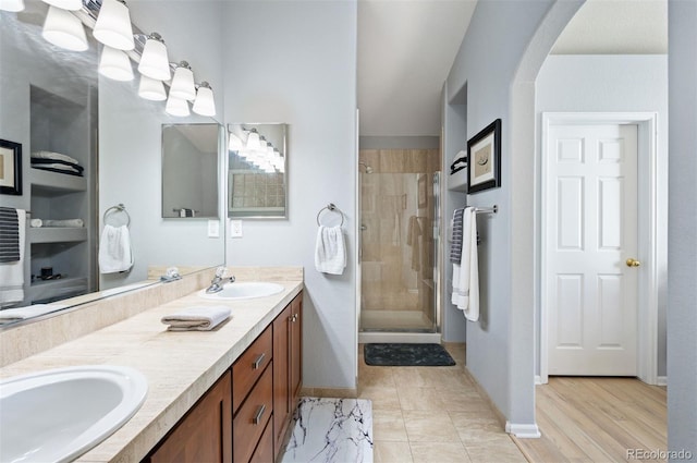 bathroom featuring vanity, a shower with shower door, and wood-type flooring