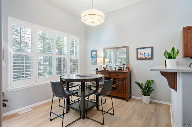 dining space featuring light wood-style floors and baseboards