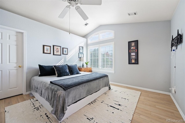 bedroom featuring light wood-style floors, vaulted ceiling, baseboards, and ceiling fan