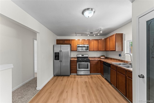 134 Hayes Dr, Colorado Springs, CO 80911 - kitchen with appliances with stainless steel finishes, brown cabinetry, and light wood-style flooring