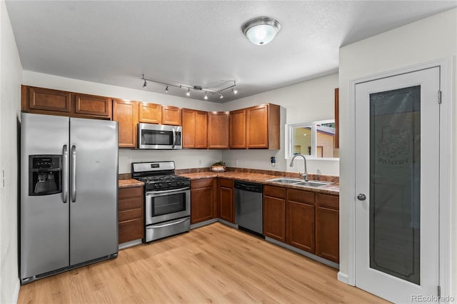 134 Hayes Dr, Colorado Springs, CO 80911 - kitchen with stainless steel appliances, light wood-style floors, and brown cabinets