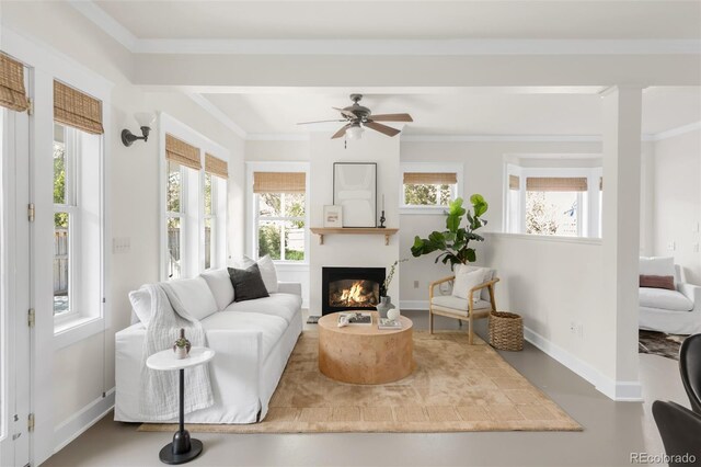 539 Baker St, Longmont, CO 80501 - living area with healthy amount of natural light, a glass covered fireplace, a ceiling fan, ornamental molding, and baseboards