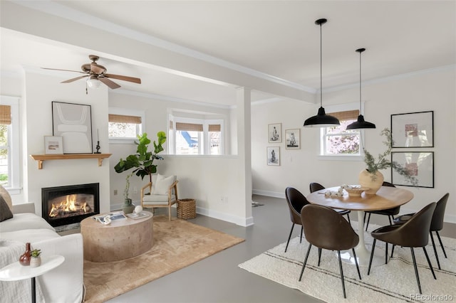 539 Baker St, Longmont, CO 80501 - dining area featuring a glass covered fireplace, finished concrete floors, a ceiling fan, baseboards, and ornamental molding