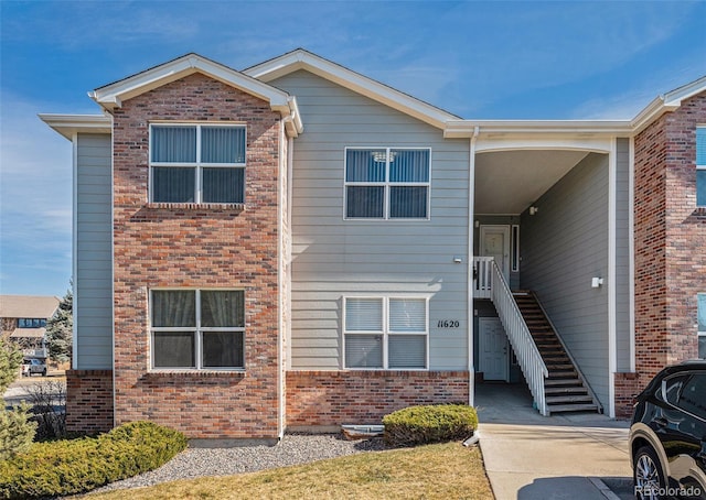 view of property featuring brick siding and stairway