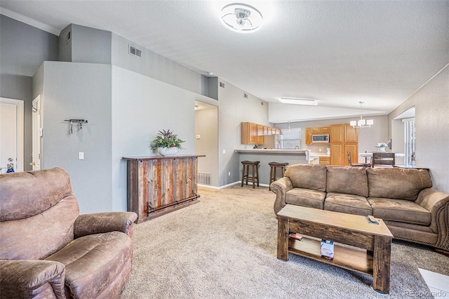 living room with visible vents, lofted ceiling, a textured ceiling, light colored carpet, and a chandelier