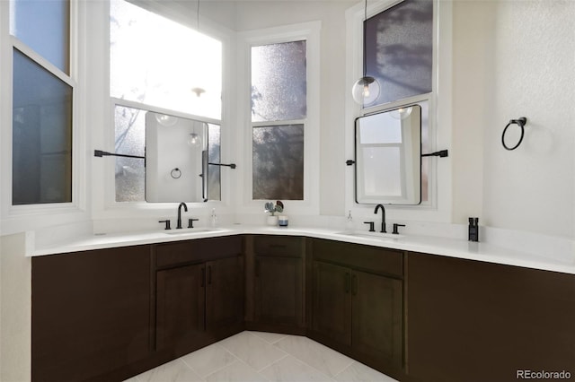 bathroom with tile patterned floors, vanity, and a wealth of natural light