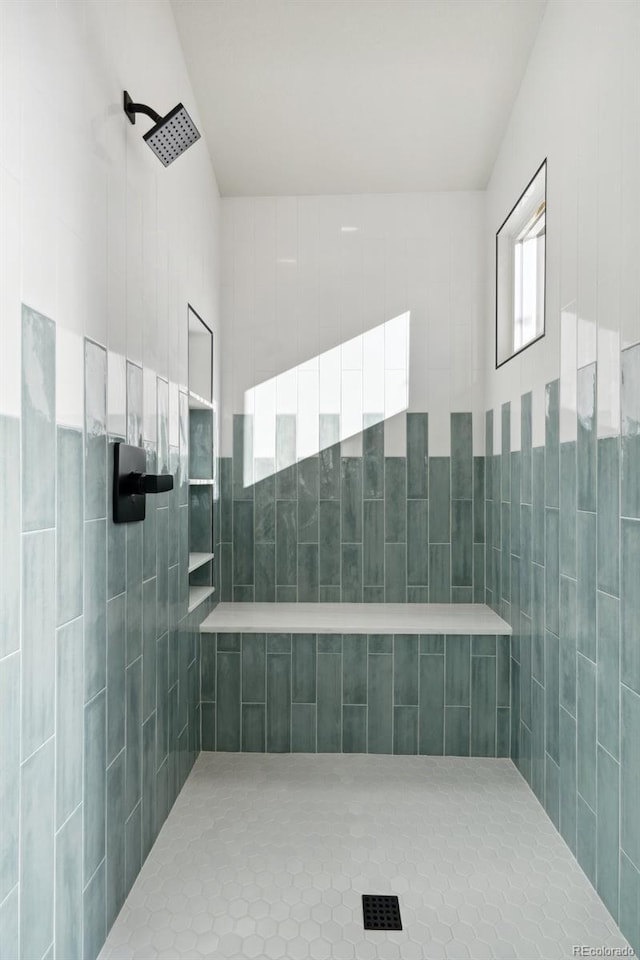 bathroom with a tile shower and tile patterned floors