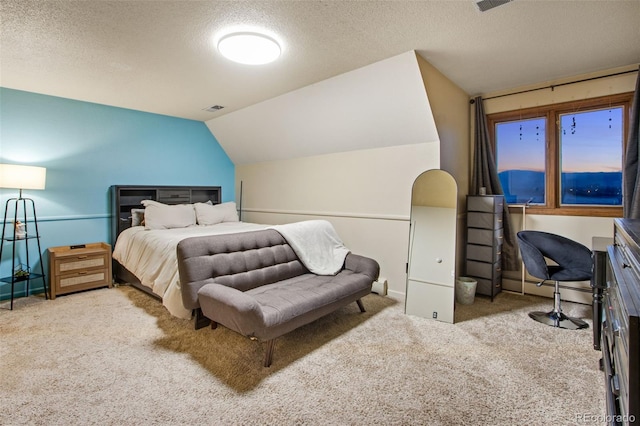 carpeted bedroom featuring vaulted ceiling and a textured ceiling