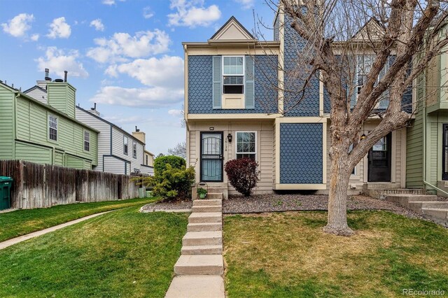 view of front of property with a front lawn, fence, and entry steps