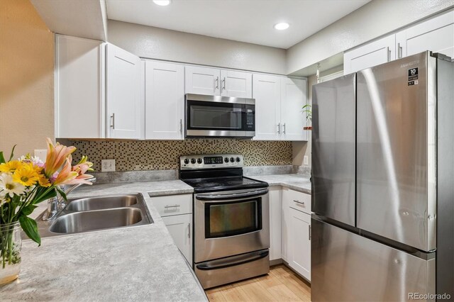 kitchen featuring light countertops, white cabinetry, appliances with stainless steel finishes, and tasteful backsplash
