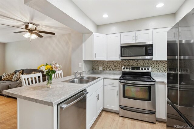 kitchen featuring a sink, light countertops, stainless steel appliances, and open floor plan