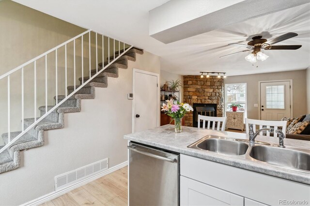 kitchen with visible vents, a sink, dishwasher, and open floor plan