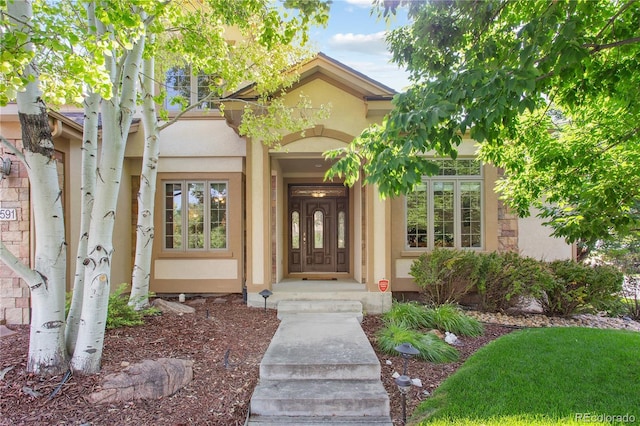 view of exterior entry with stucco siding