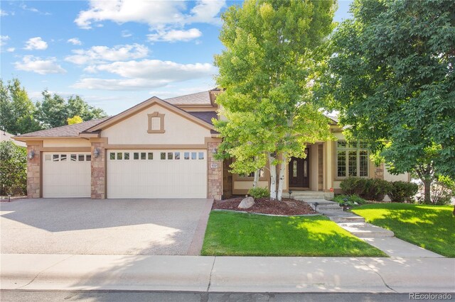 view of front facade with stone siding, stucco siding, driveway, and an attached garage