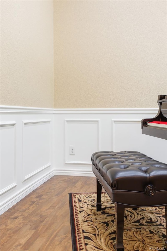 sitting room featuring wainscoting and wood finished floors