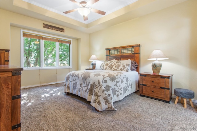 bedroom with light colored carpet, a raised ceiling, and ceiling fan