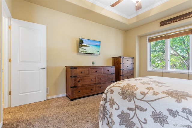 carpeted bedroom with baseboards, a raised ceiling, ceiling fan, and crown molding