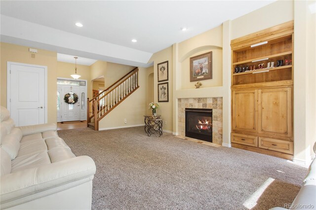 living area with baseboards, carpet, a tiled fireplace, stairs, and recessed lighting