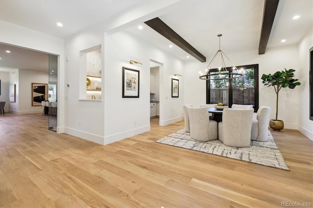 dining area with a notable chandelier, beamed ceiling, and light hardwood / wood-style flooring