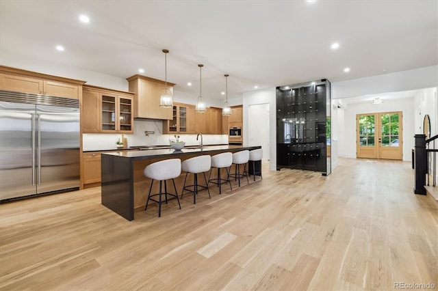 kitchen featuring pendant lighting, light hardwood / wood-style flooring, and appliances with stainless steel finishes