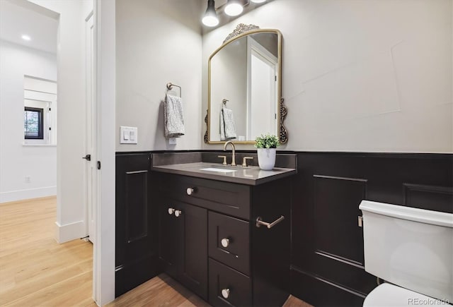 bathroom featuring hardwood / wood-style flooring, toilet, and vanity