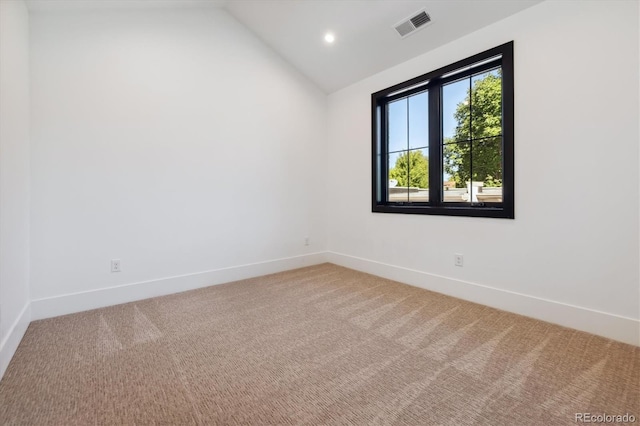 unfurnished room with carpet floors and vaulted ceiling